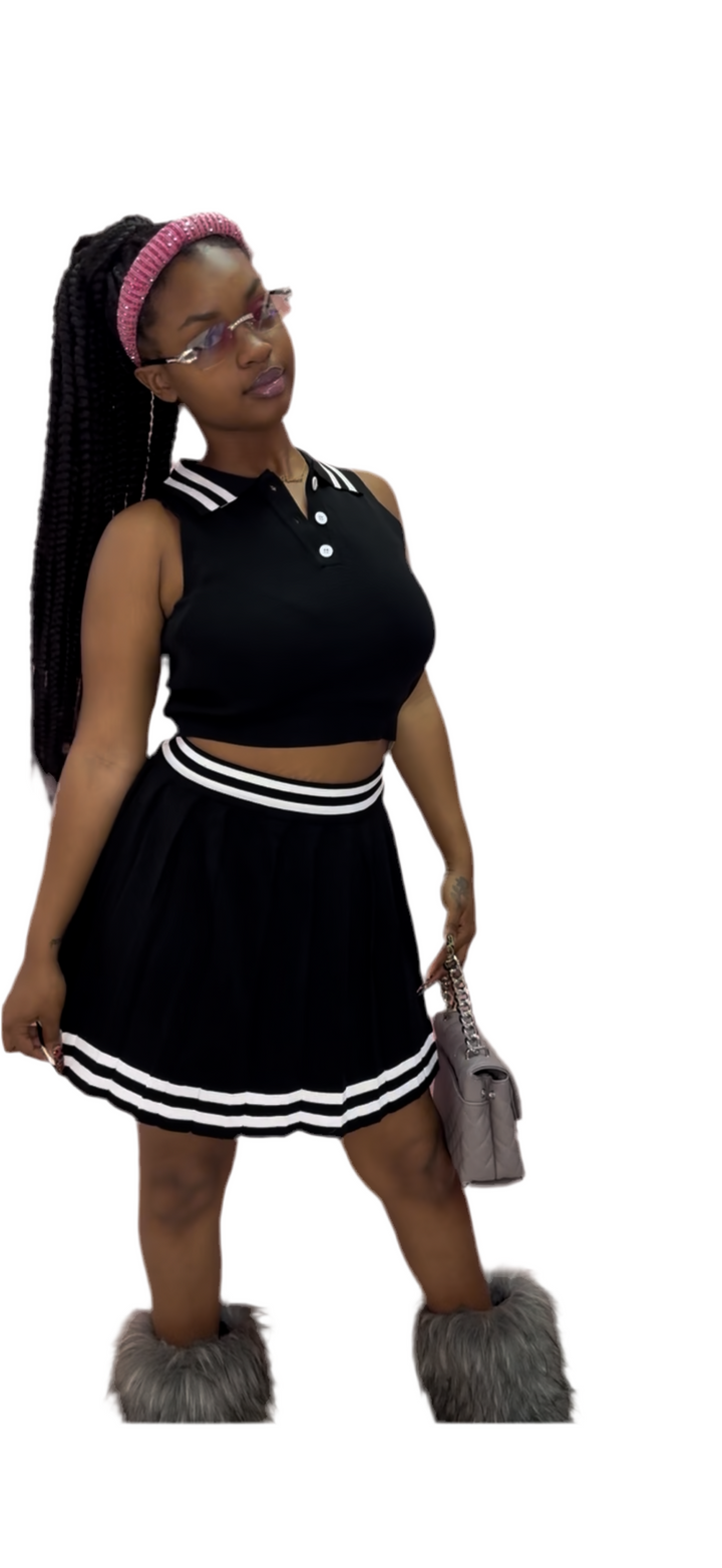 A woman wearing a black crop top and a matching ruffle skirt, with a handbag and high heels.