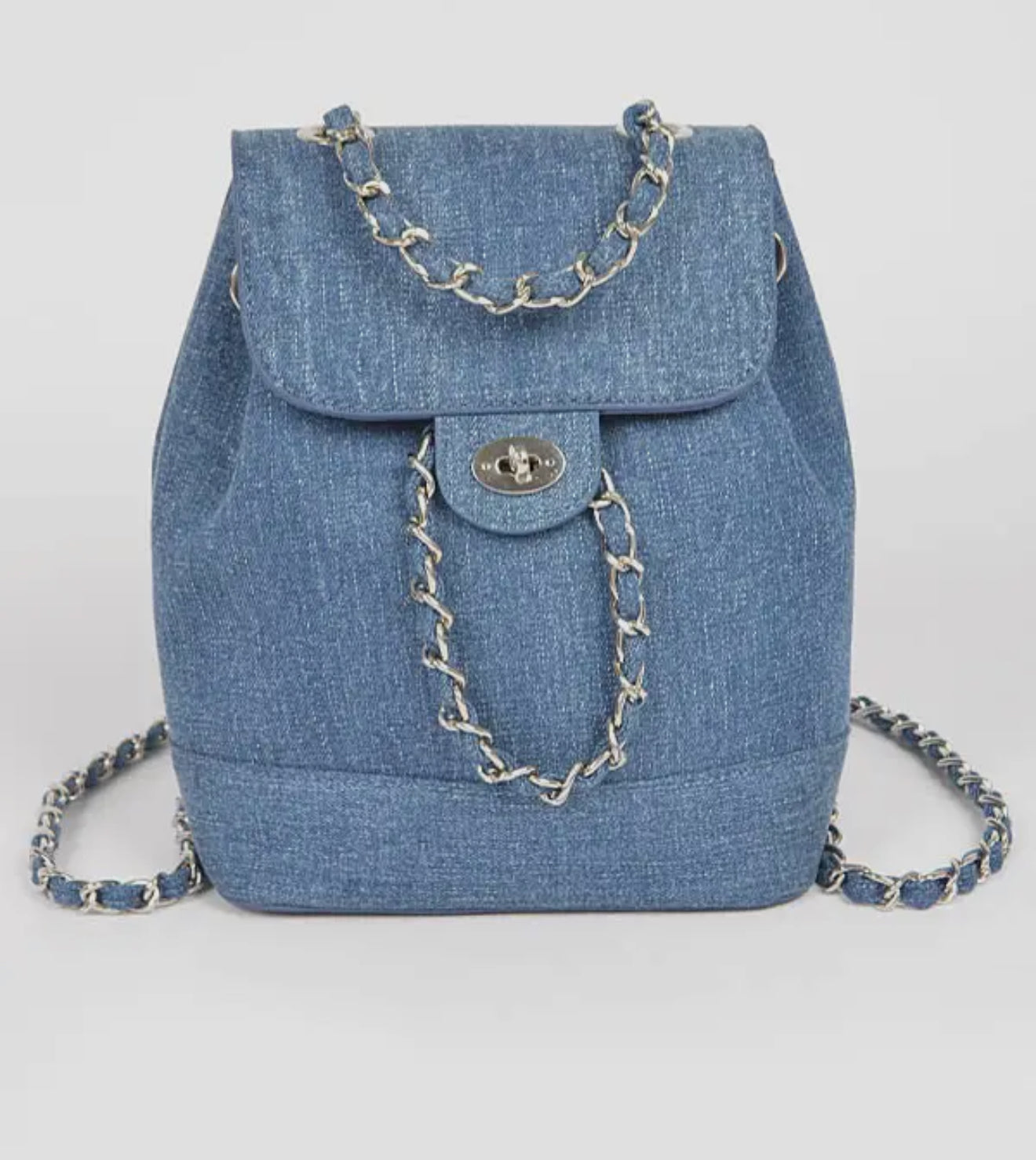 Blue denim backpack with chain details on a light gray background