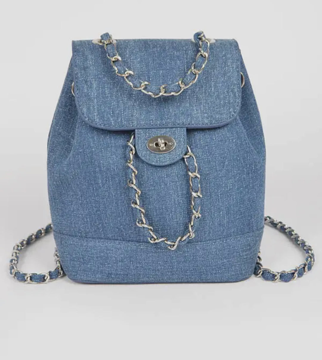 Blue denim backpack with chain details on a light gray background