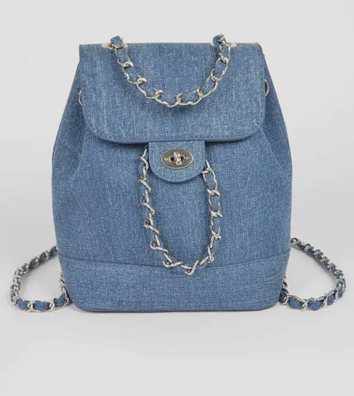 Blue denim backpack with chain details on a light gray background