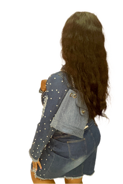 Person wearing a denim jacket with white polka dots and a denim skirt on a white background