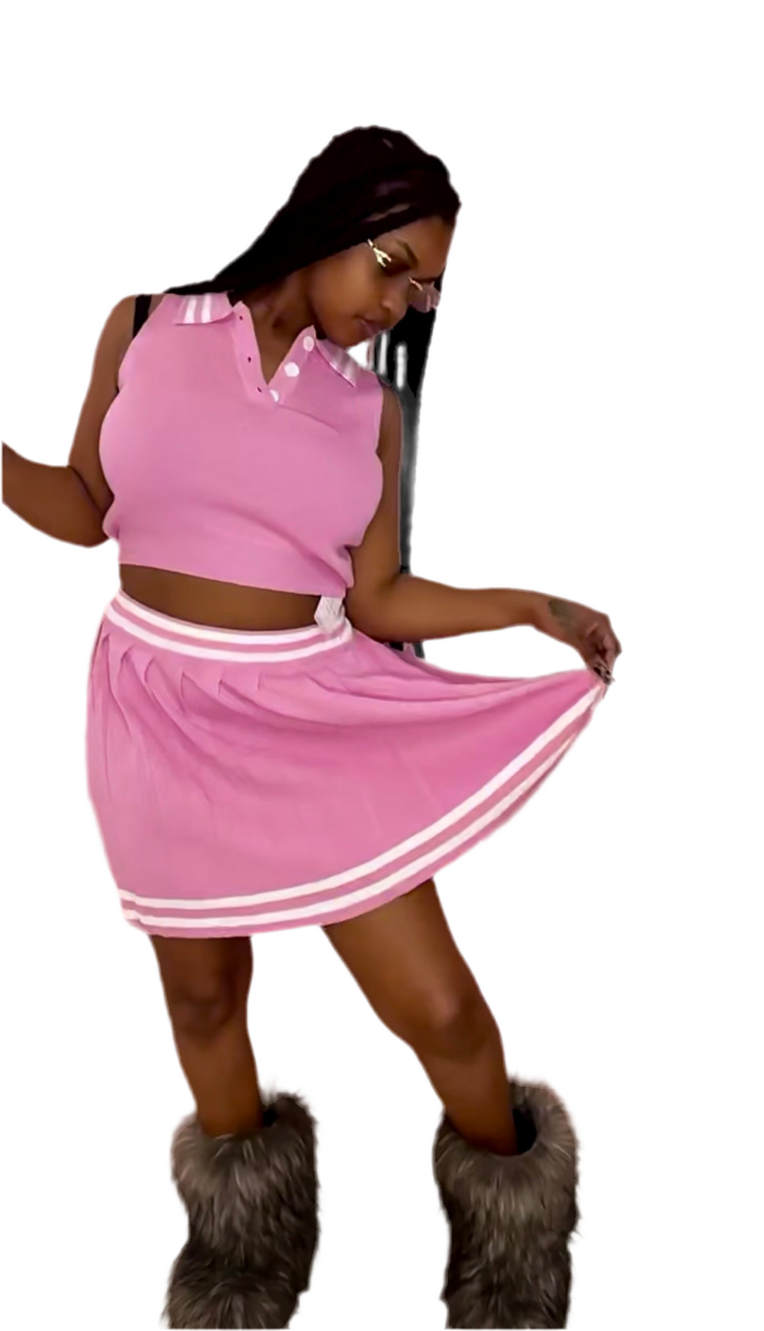 A woman wearing a pink crop top and a matching ruffle skirt, with a handbag and high heels.